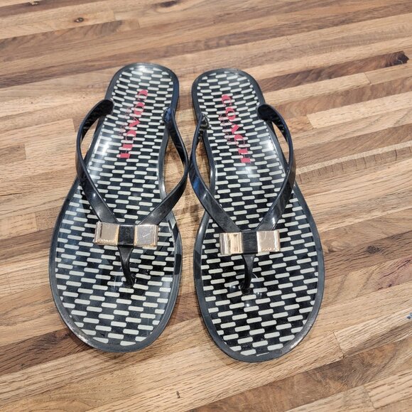 Coach Landon jelly flip flops in black with a gold bow and white pattern. - Picture 2 of 12